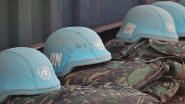 United Nations blue helmets laid out in a row on top of flak jackets